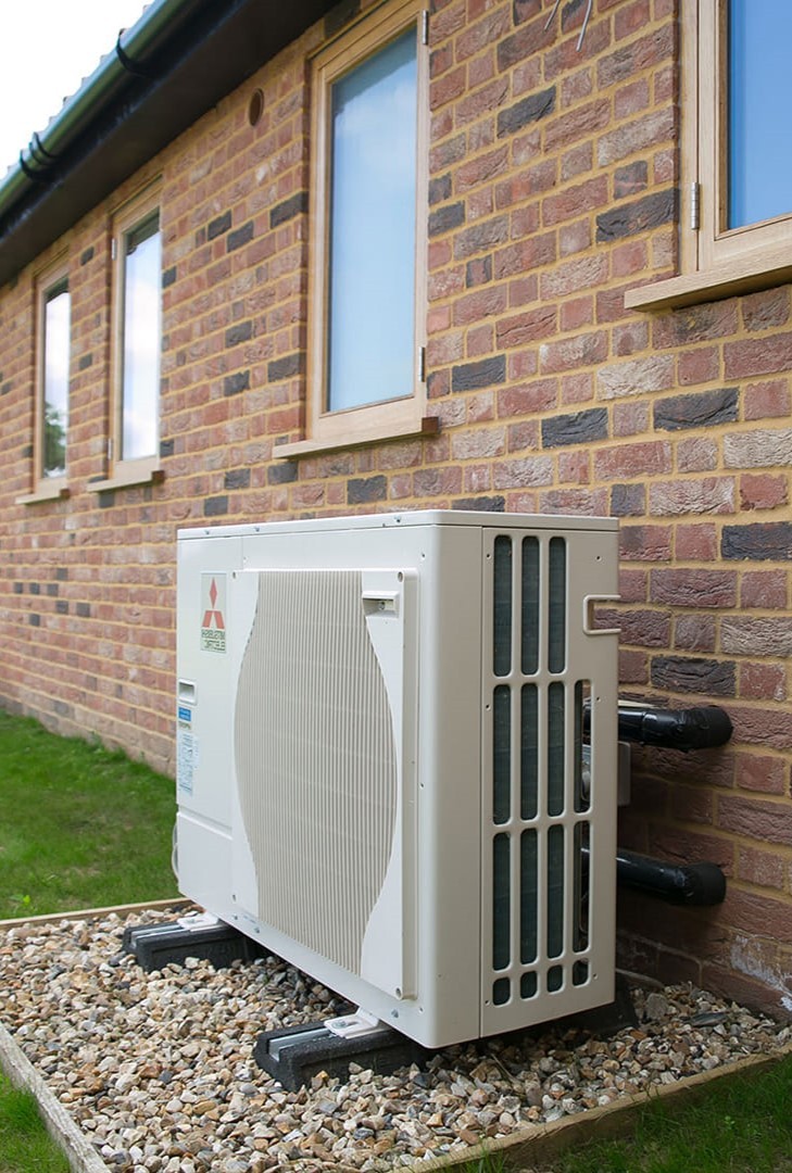An air source heat pump (ASHP) installed outside of a small commercial building