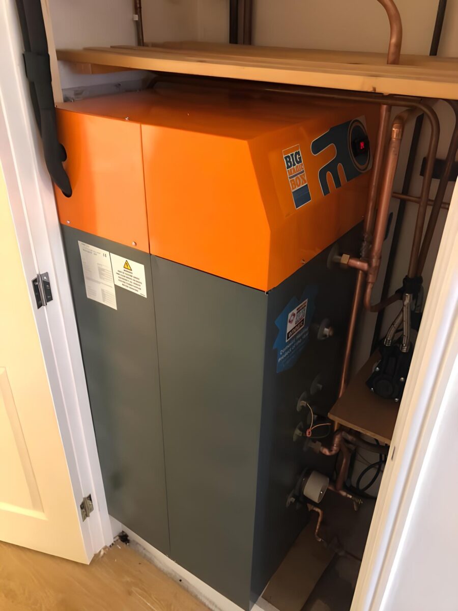 A large orange and grey boiler with the "Big" logo, installed in a cupboard in Fife.
