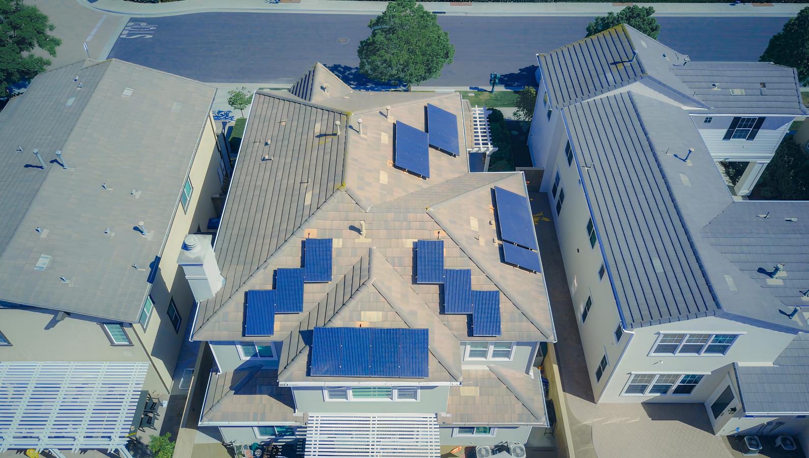 A photo showing an aerial view of solar panels neatly arranged on the roof of a house, highlighting an efficient residential solar energy system.