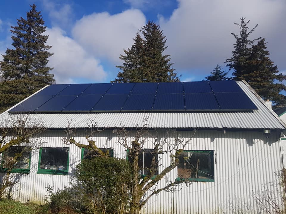 Solar PV panels installed on a residential property in Scotland, showcasing a rooftop solar energy system under clear skies.