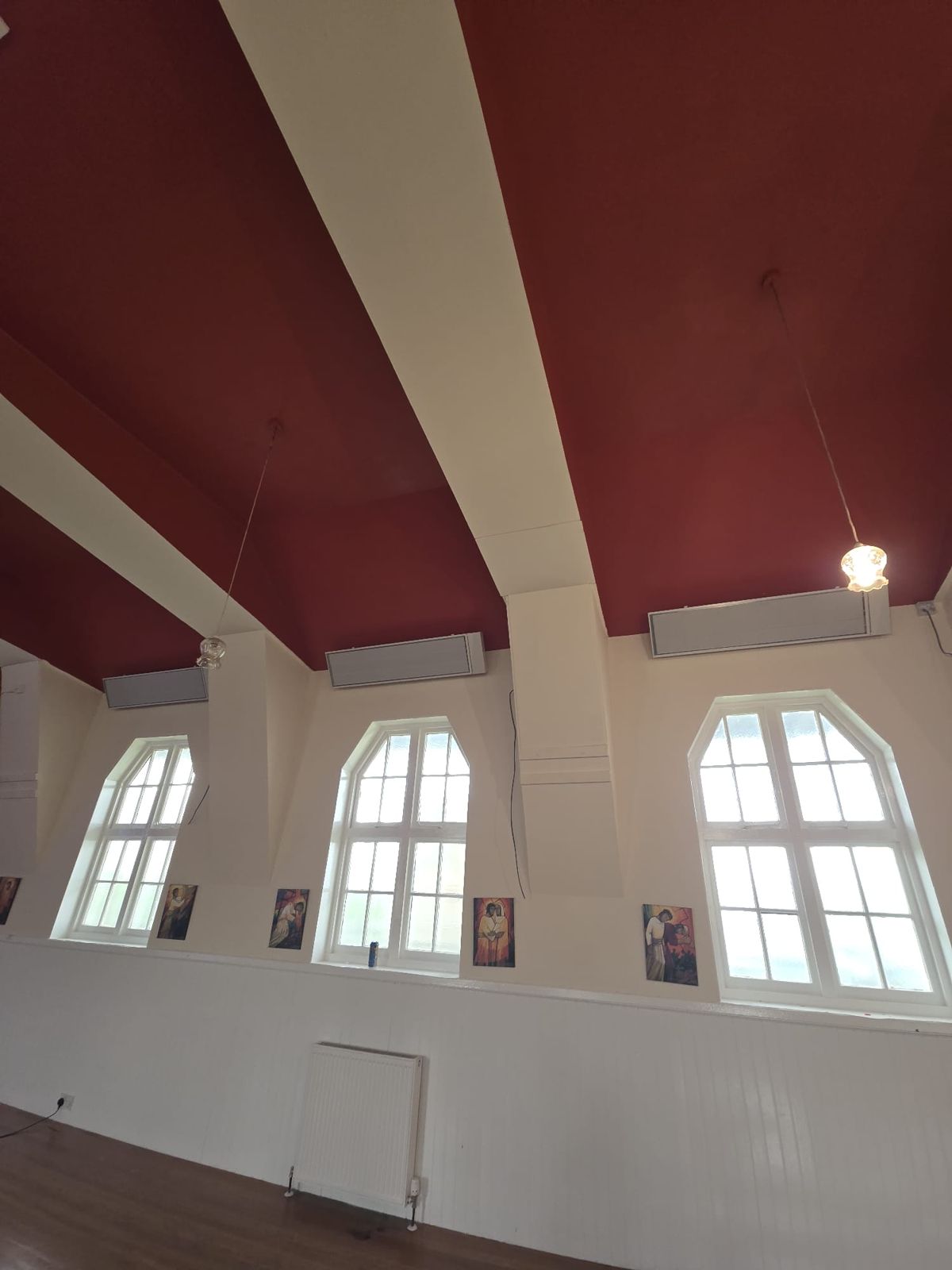 Infrared bar heaters on a red church ceiling