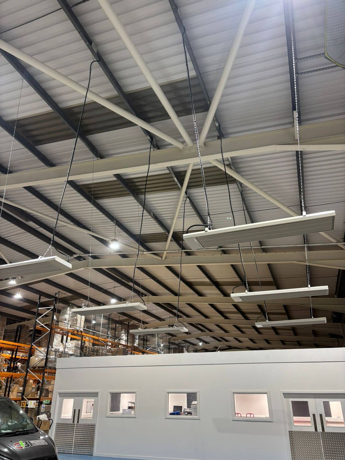 Infrared heaters suspended from a warehouse roof